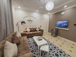 a living room with a couch and a table at نسمة كيان للشقق المخدومة Nasma Kayan Serviced Apartments in Jeddah