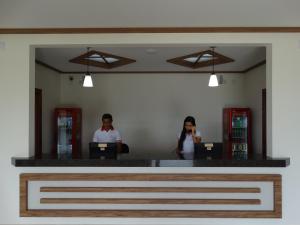 two people standing in front of a mirror at Hotel e Restaurante Sabor de Minas in Salinas