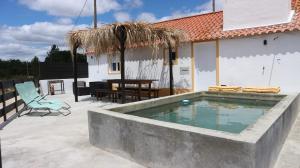 a patio with a swimming pool and a house at Monte da Lua in Montargil