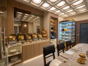 a restaurant with a table and chairs and a counter with food at Hotel Serenity Suites in Nagpur