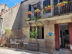 a building with a table and chairs on a balcony at Logis du mont in Saint-Sernin-du-Plain