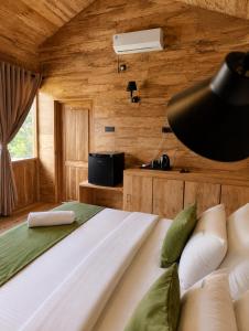 a bedroom with a large bed in a wooden room at J Villa Sigiriya - Private Pool Chalets in Dambulla +25 photos