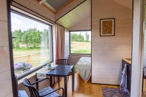 a tiny house with a table and a window at Suur Muna Apple Garden Tiny Houses in Haanja +42 photos