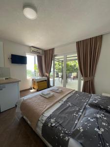 a bedroom with a large bed and a desk and windows at Villa Stefanoski in Konsko