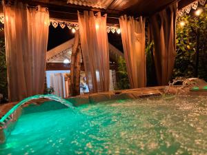 a jacuzzi tub in a room with curtains at Le Chalet Atypique in Saint-Pierre