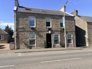 an old stone building on the side of a street at 'Gordon' in ApartNest Auchterarder in Auchterarder