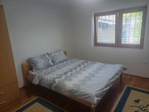 a bed in a bedroom with a window at Apartman BelSa in Sarajevo