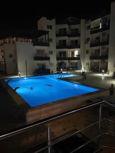 a large blue swimming pool in front of a building at night at Smart Home near beach and pool in Sharm El Sheikh
