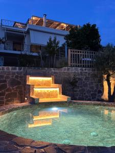 a swimming pool with stairs in front of a building at Trigono Suites - Karat in Politika
