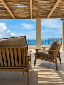 a bench on a balcony with a view of the ocean at Trigono Suites - Karat in Politika