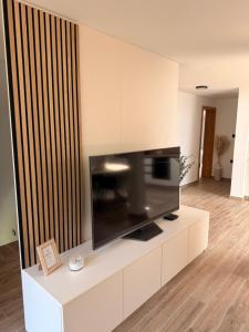 a flat screen tv sitting on top of a white entertainment center at Apartma Julia in Semič