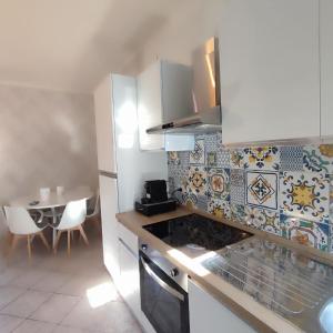 a kitchen with white cabinets and a table with chairs at Casa Iris in Somma Lombardo