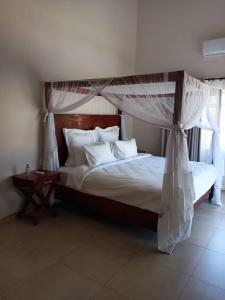 a bedroom with a bed with a canopy at Judith & Sylvester Hideaway in Victoria Falls