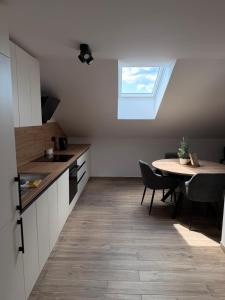 a kitchen with a table and a window on the ceiling at Apartma Julia in Semič +2 photos