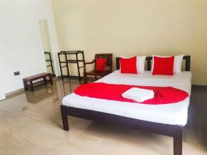 a bedroom with a large bed with red pillows at Dee Holidays in Moratuwa