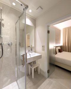 un bagno con lavandino, doccia e letto di Hotel Lauri a Macerata Altre 80 foto