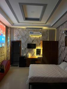 a bedroom with a bed and a tv on a wall at Motel Long Thành Quang in Long Thành