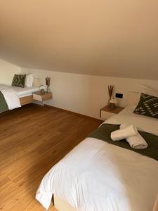 two beds in a room with wooden floors at Apartma Julia in Semič