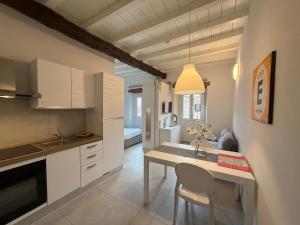 a kitchen with white cabinets and a dining table at Monza Downtown House Via Bartolomeo Zucchi 5 Monza in Monza