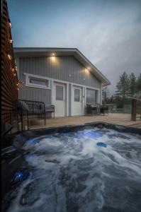 a hot tub with snow in front of a house at Joulupukin talolla in Rovaniemi