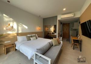 a bedroom with a large bed and a couch at 202 HOUSE near Bangtao Muay Thai & MMA in Ban Thalat Choeng Thale