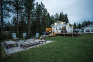 a house with a bench and chairs in a yard at Joulupukin talolla in Rovaniemi