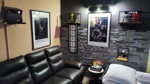 a living room with a leather couch and a stone wall at Zagora Hills Premium Apartman in Krapina