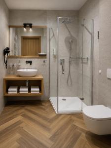 a bathroom with a shower and a toilet and a sink at Hotel Szara Willa in Opole
