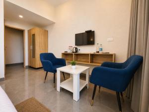 a room with two chairs and a table and a tv at Hotel Olive Sunny Enclave, Near Airport Road, Mohali in Kharar