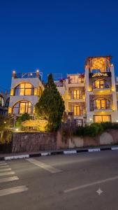 a large building with lights on in front of a street at Zone Guest House Bellapais in Kyrenia