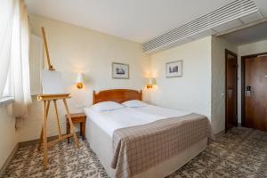 a bedroom with a large bed and a table at Rixwell Collection Savoy Boutique Hotel in Tallinn