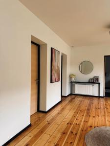 an empty living room with wooden floors and a door at The Forest room in Ikšķile