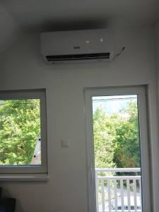 two windows in a room with a door and a balcony at Apartman Nature in Konjic