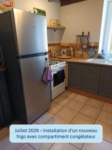 a kitchen with a refrigerator and a stove at Au repos de la Sioule in Menat +46 photos