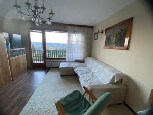 a living room with a white couch and a balcony at Panorama Hause in Podplat