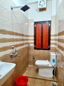 a bathroom with a toilet and a sink at Hotel Sada Shiv Inn in Deoghar