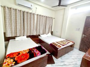 a room with two beds and a window at Hotel Sada Shiv Inn in Deoghar
