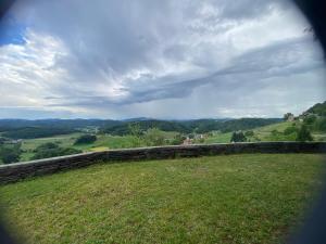 a view of a field with a stone wall at Panorama Hause in Podplat +3 photos