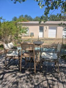 a wooden table and chairs on a deck at La petite maison in Gourdon