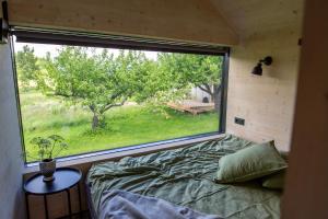 a bedroom with a large window in a tiny house at Suur Muna Apple Garden Tiny Houses in Haanja