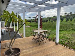 a wooden deck with a table and a potted plant at Oak Vue cottage in Korumburra