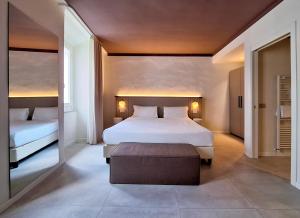 una camera da letto con un grande letto bianco e un pouf di Hotel Lauri a Macerata