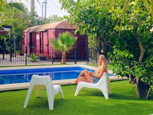 a woman sitting in a chair next to a pool at OasisTrain 01 - PISCINA in Murcia