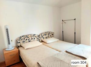 a bedroom with two beds and a lamp on a table at Villa Chaloski in Peštani