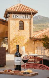 a bottle of wine and a glass on a table at La Venta de Bodegas Ostatu in Samaniego