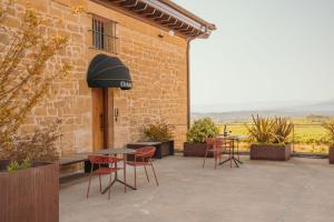 a patio with tables and chairs in front of a building at La Venta de Bodegas Ostatu in Samaniego