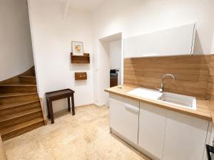 a kitchen with white cabinets and a sink and a staircase at Maison de ville hypercentre Béthune in Béthune