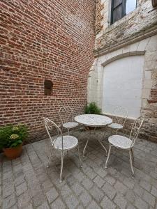 a patio with a table and chairs next to a brick building at Maison de ville hypercentre Béthune in Béthune