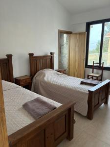 a bedroom with two beds and a chair and a window at LasaThea in Lasa