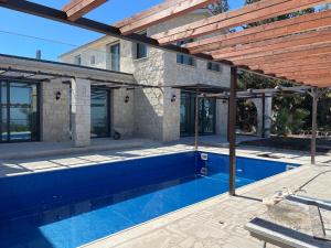 a house with a swimming pool and a wooden pergola at LasaThea in Lasa